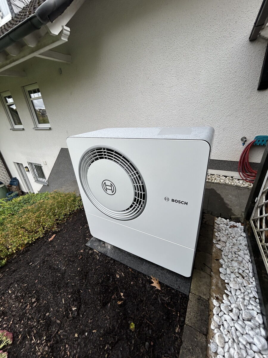 Bosch-Wärmepumpe im Garten eines Einfamilienhauses mit Kiesbett