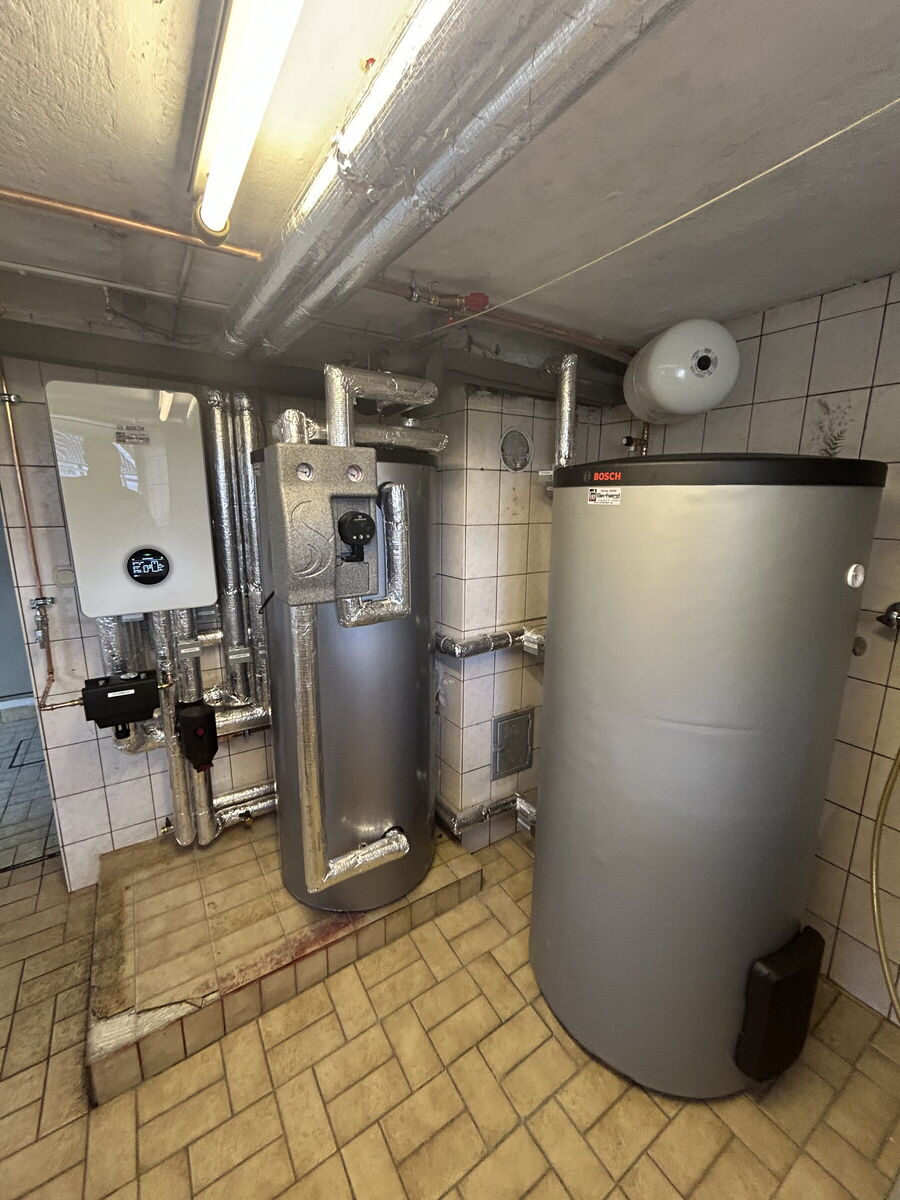 Heizraum mit Warmwasserspeicher, Pufferspeicher und Wärmepumpen-Inneneinheit