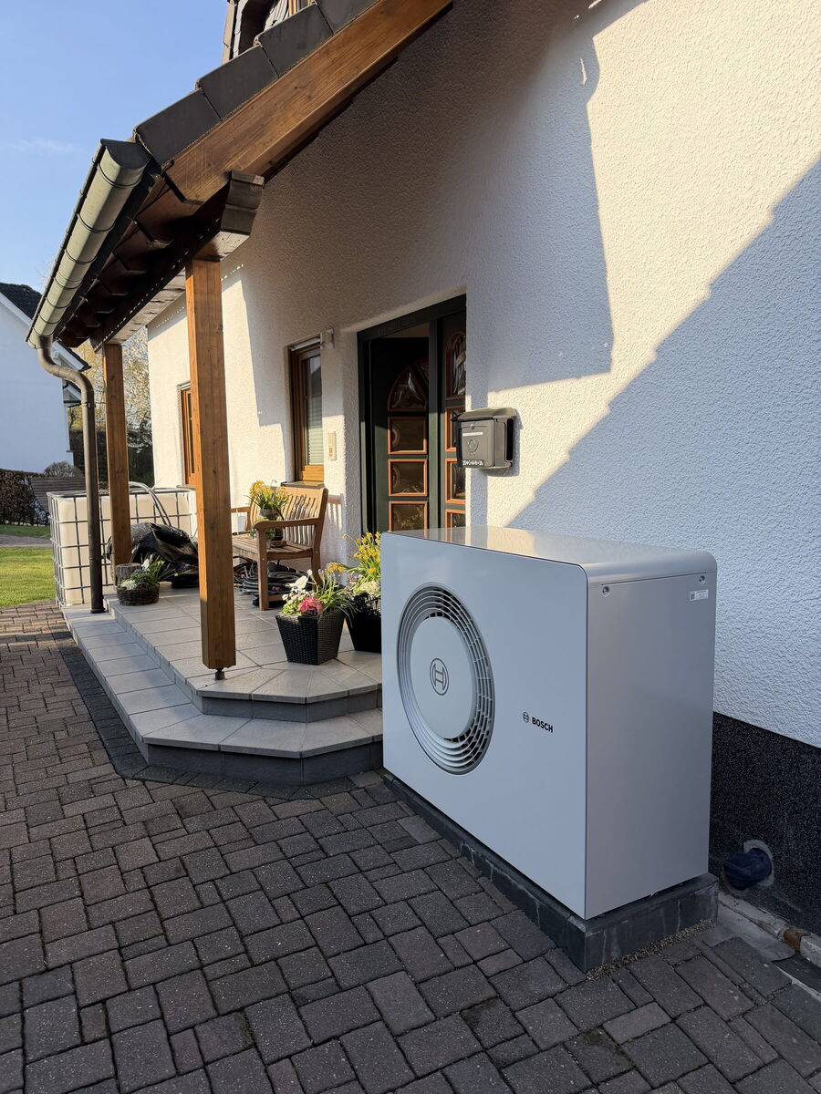 Bosch-Wärmepumpe neben dem Hauseingang eines Einfamilienhauses